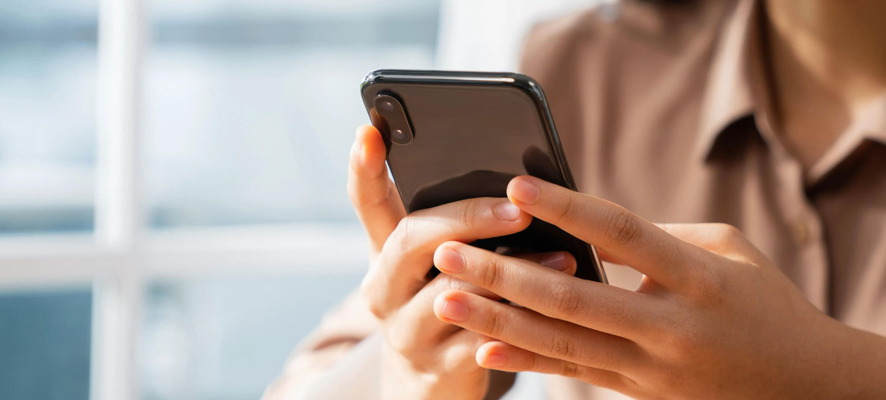 cropped photo of a woman's hands holding a smartphone
